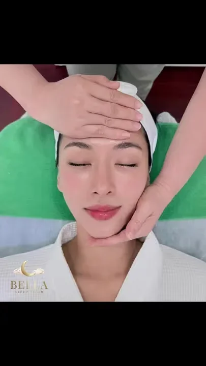 Eine Gesichtsmassage von Hand, der Gast unter einem Handtuch des Bella Sleep Salon