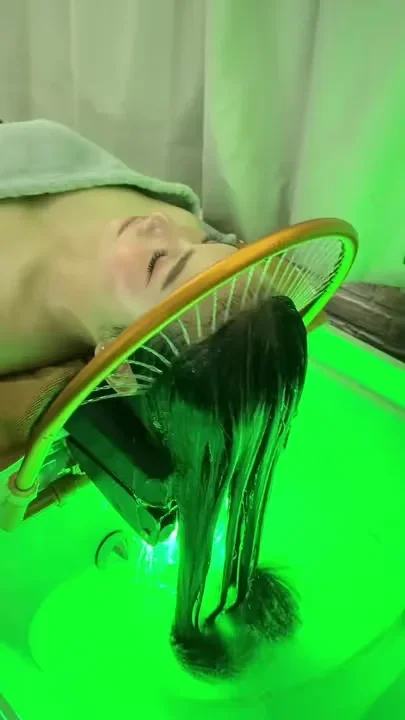 Haarwäsche unter dem Wasserbogen, in grünem Licht