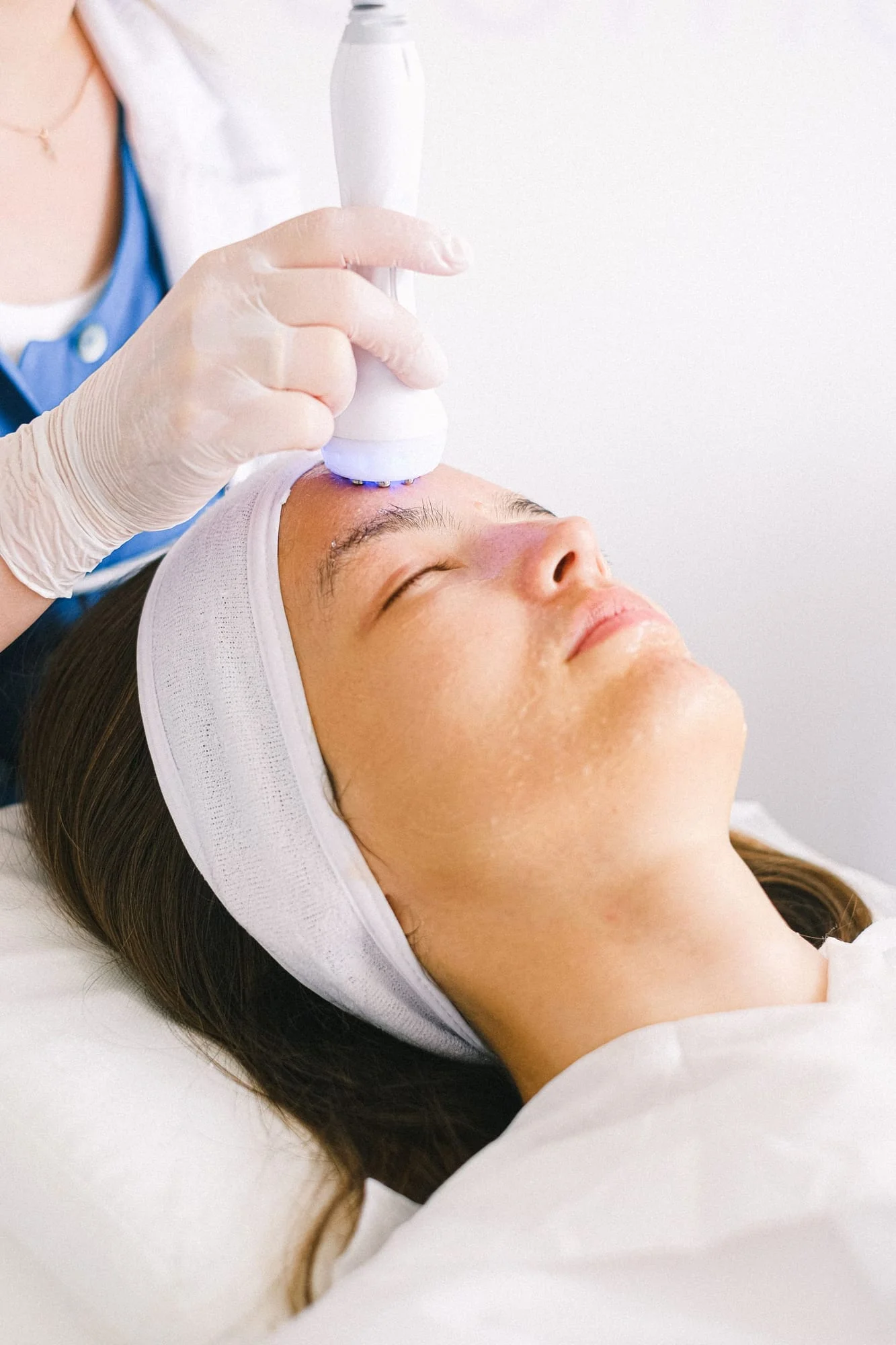 Ultrasonic skin cleansing on a client’s forehead.