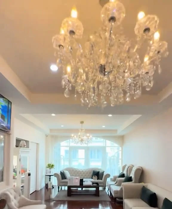Bella’s lounge under a crystal chandelier, with the arched windows beyond.
