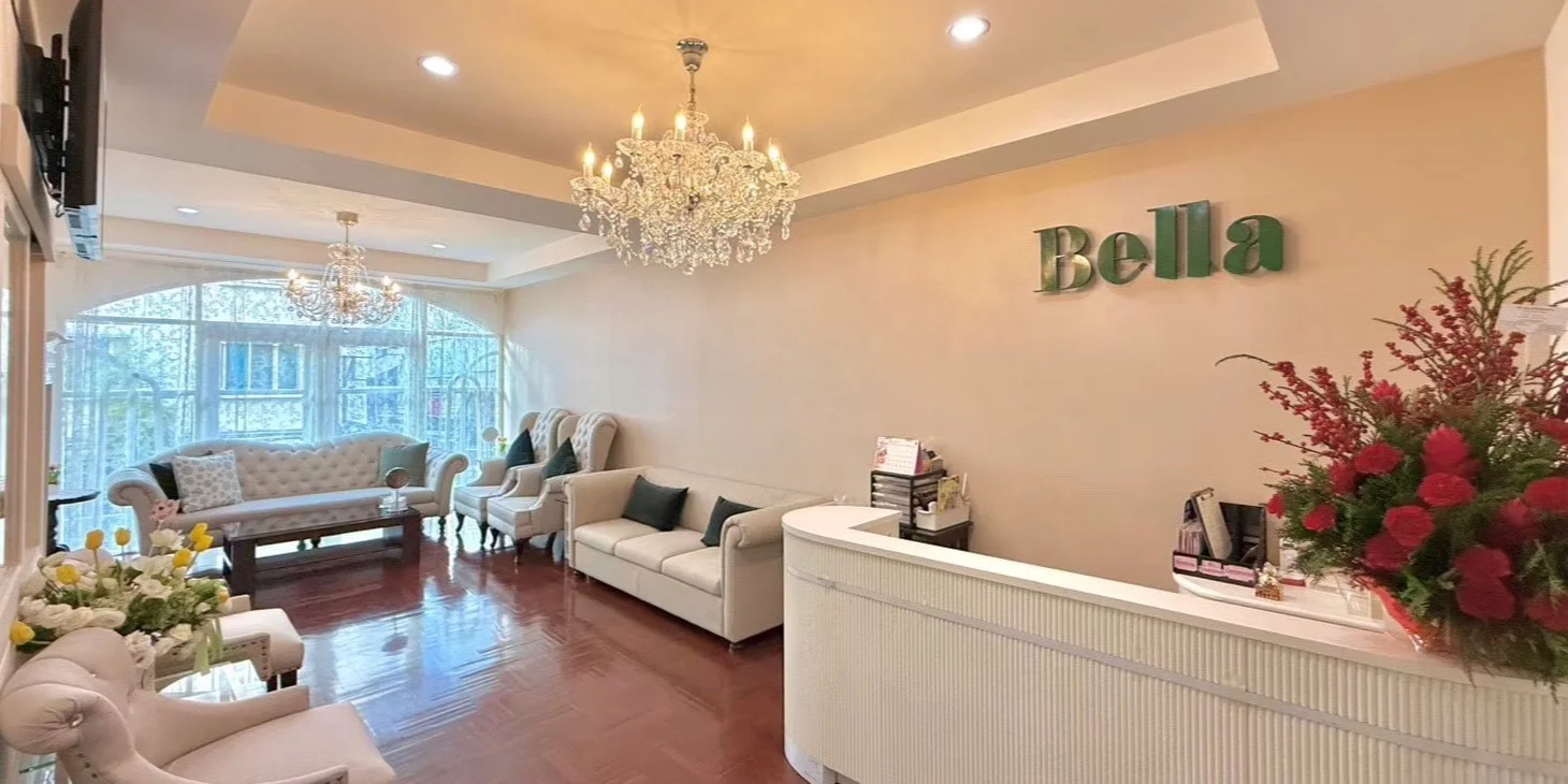 Bella Clinic’s reception: an ivory counter beneath the green Bella lettering, crystal chandeliers and cream sofas.